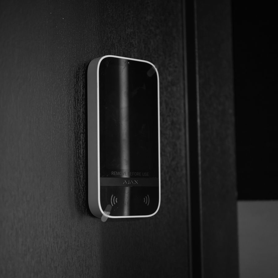 Touchscreen access keypad mounted beside a door